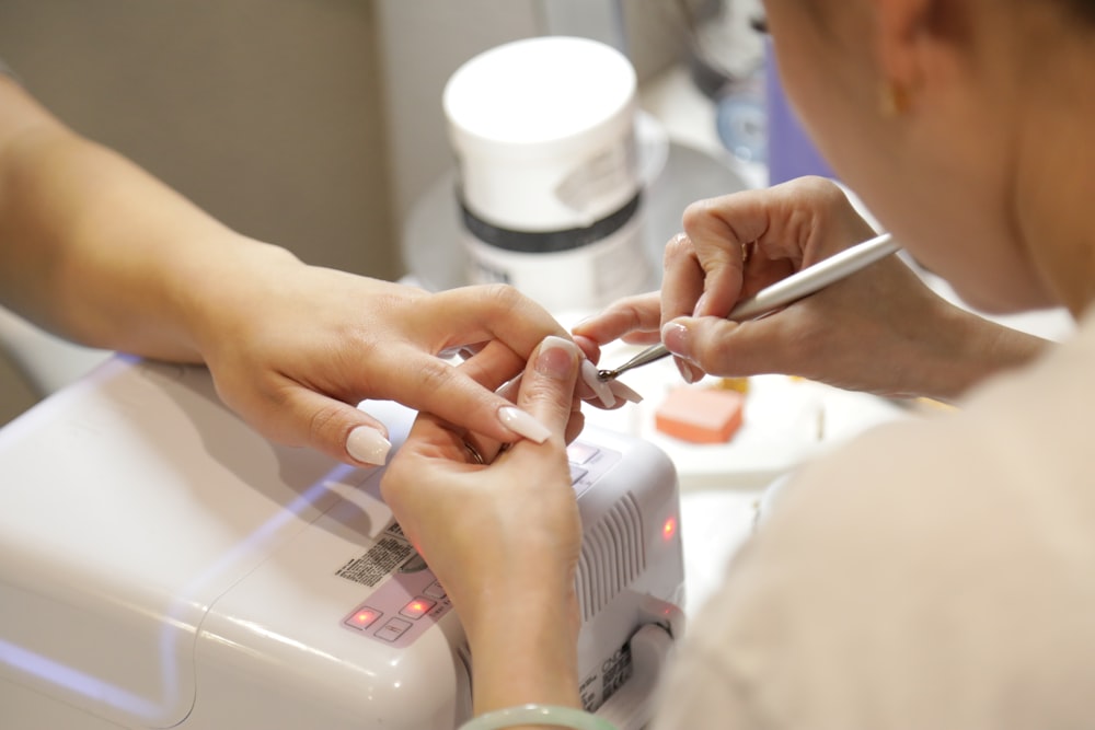 a woman getting her nails done at a nail salon