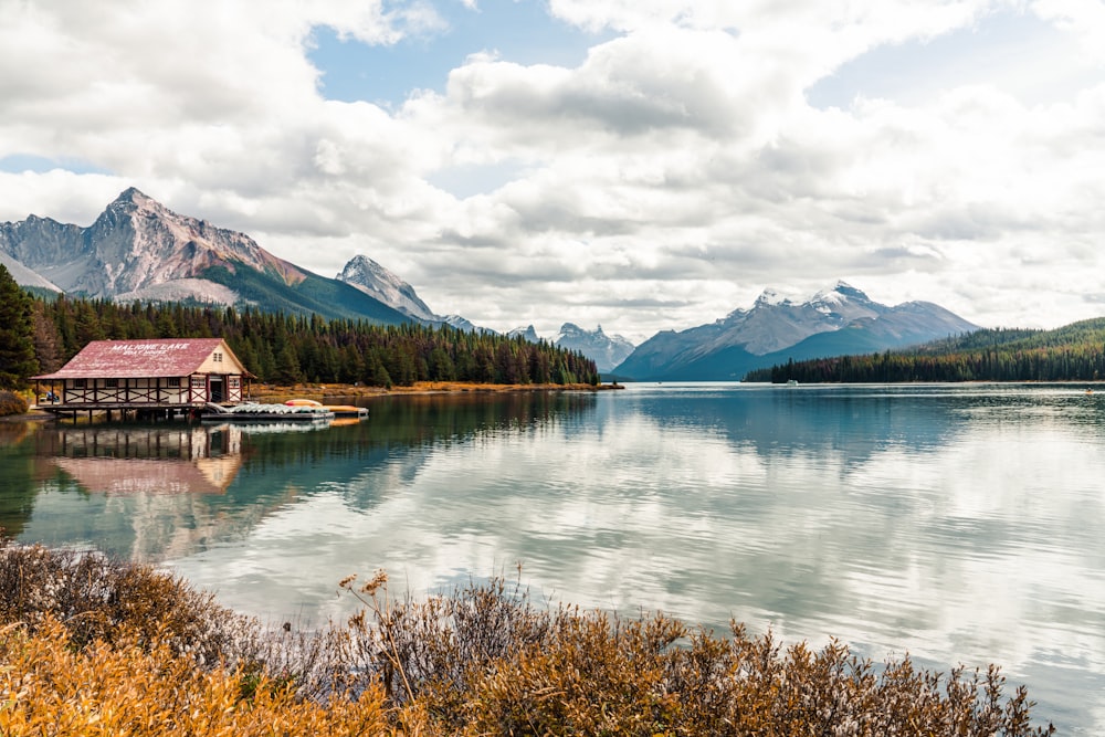 a house on a lake with mountains in the background