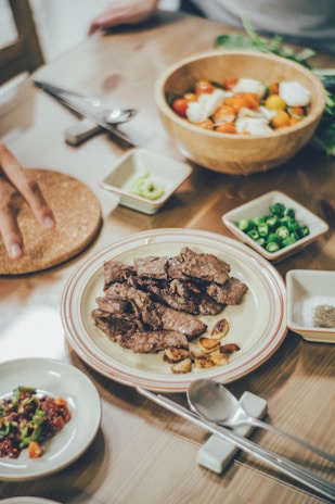 A beautifully arranged table featuring a variety of grilled dishes and colorful side salads.