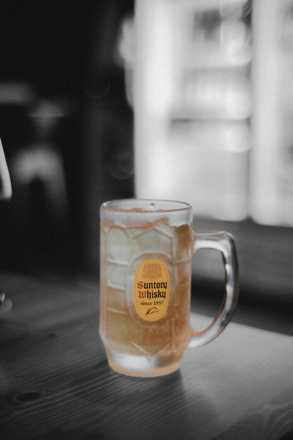 a glass of beer sitting on top of a wooden table