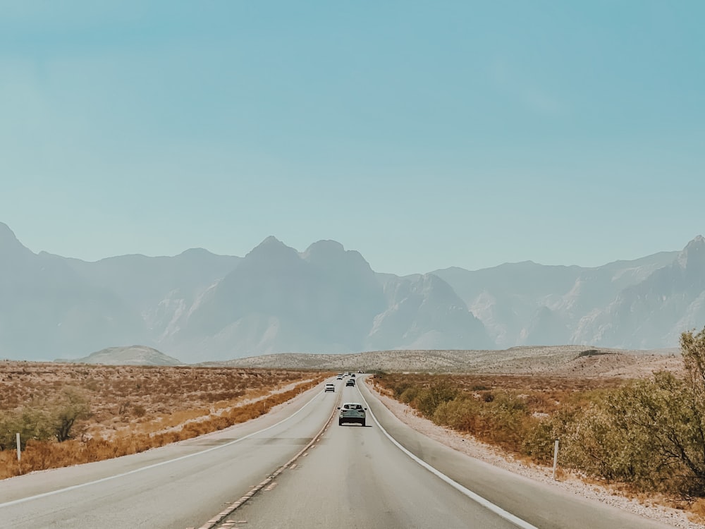 山を背景に砂漠の道を走る車