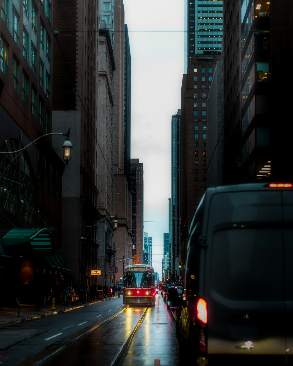 a bus driving down a street next to tall buildings