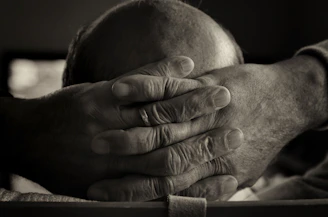 A close-up of a weathered hand holding a faded photograph, symbolizing memories under dictatorship.