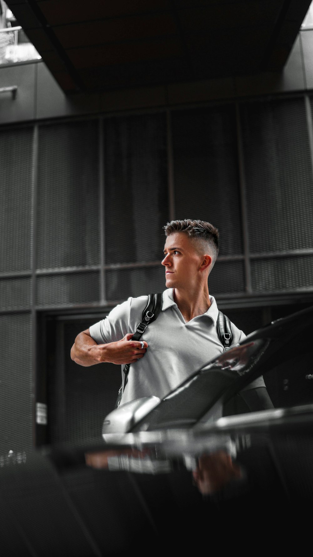 a man standing next to a car in a garage