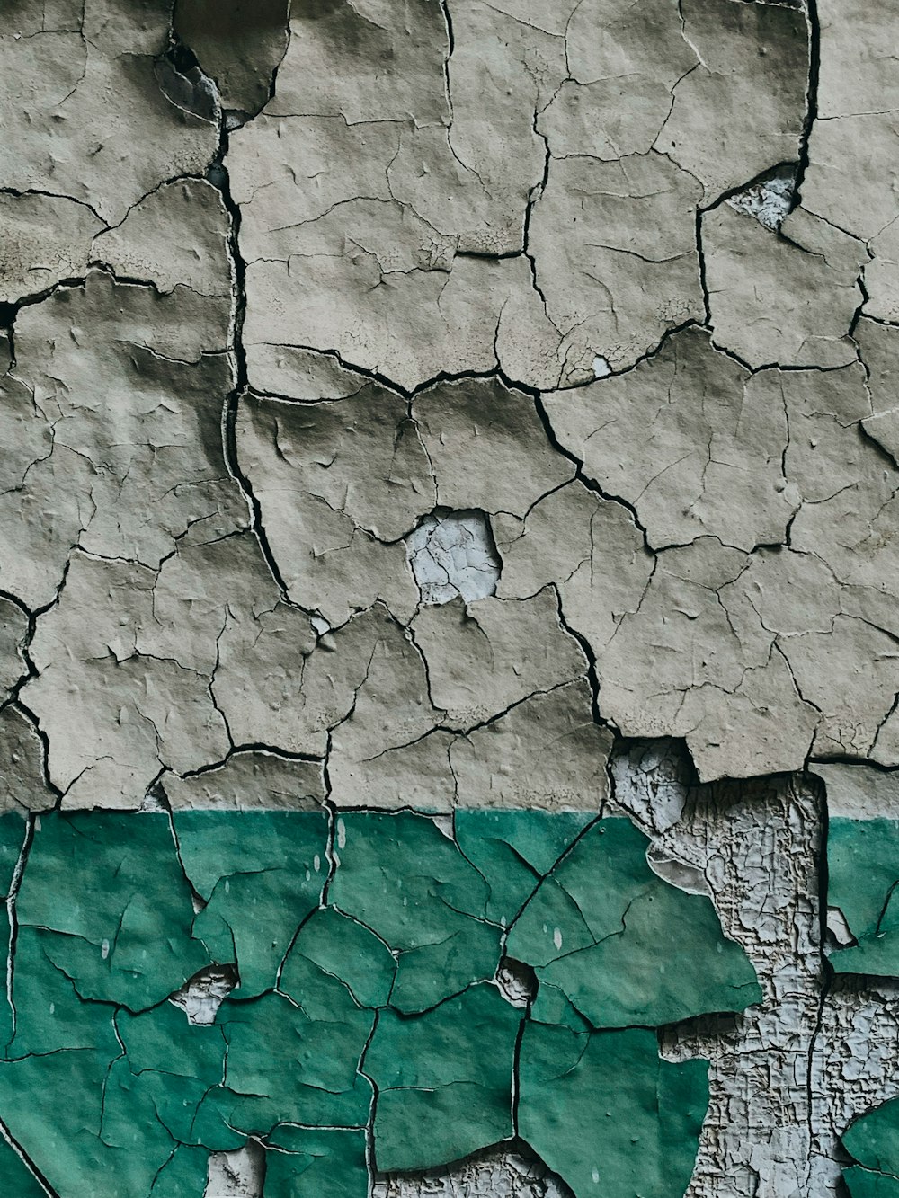 eine Nahaufnahme einer rissigen Wand mit grüner Farbe