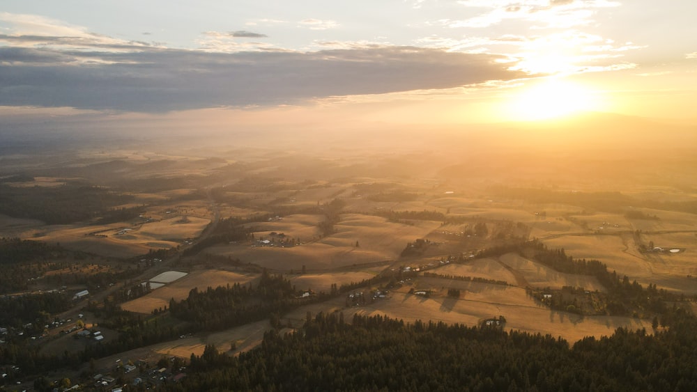 the sun is setting over a rural area