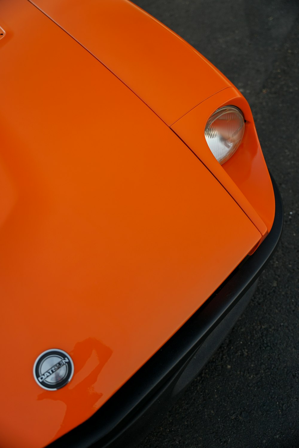 a close up of the front of an orange sports car