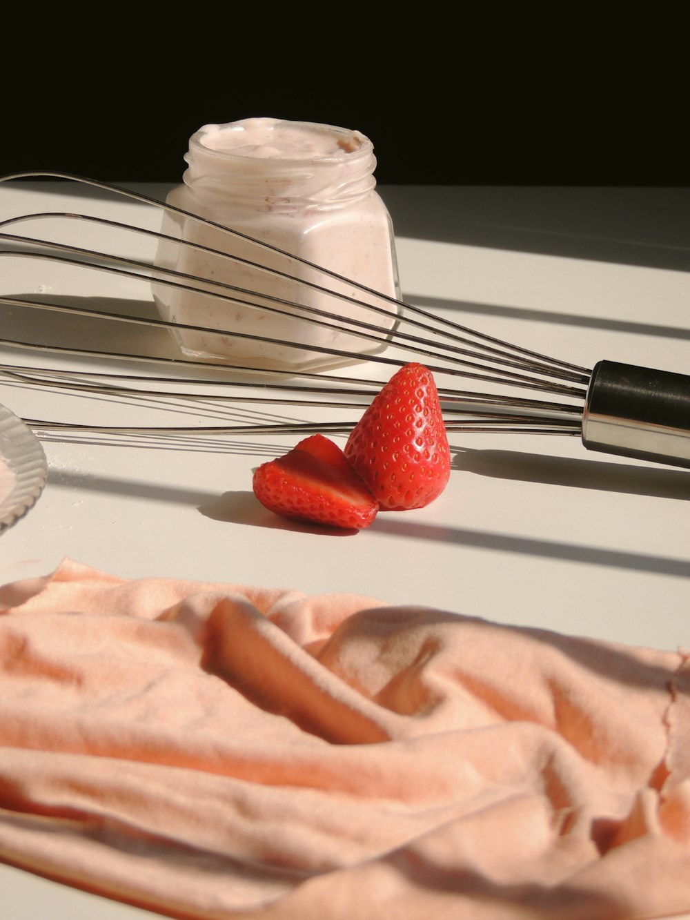 a whisk and some strawberries on a table