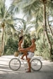 a man riding on the back of a bike next to a woman