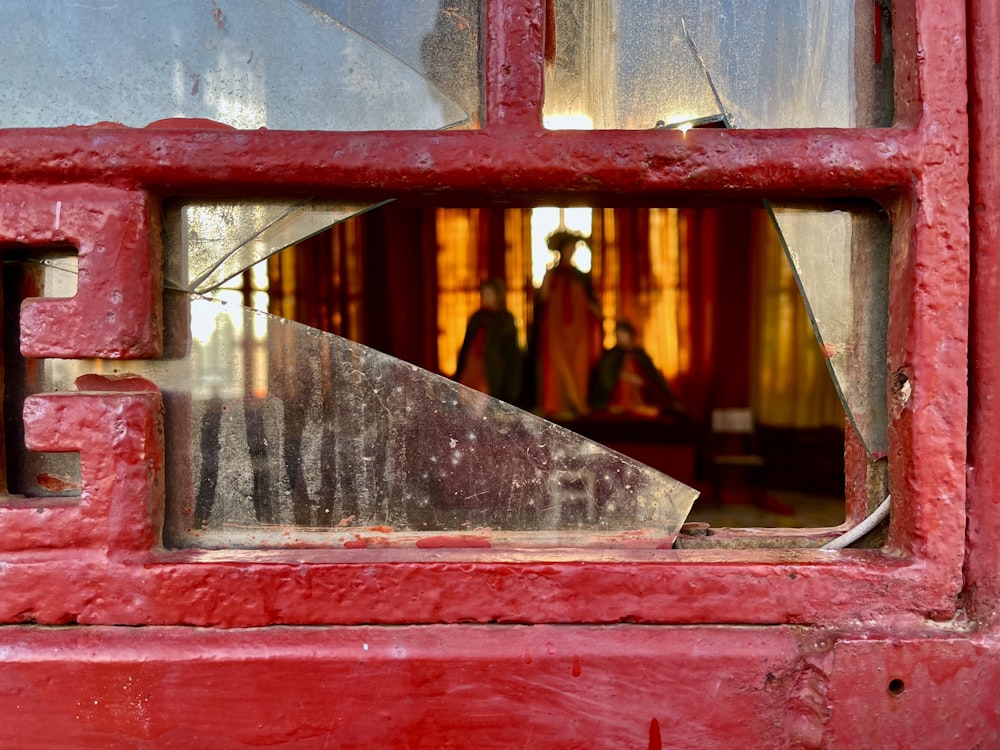 a red door with a broken glass window