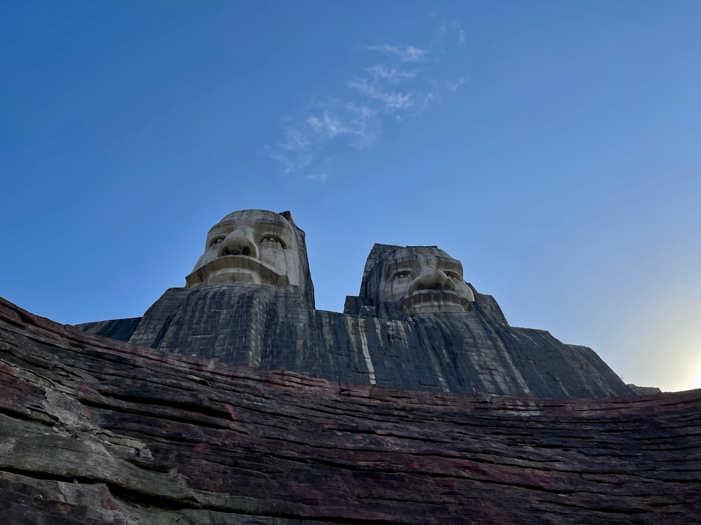 two large statues of heads on top of a mountain