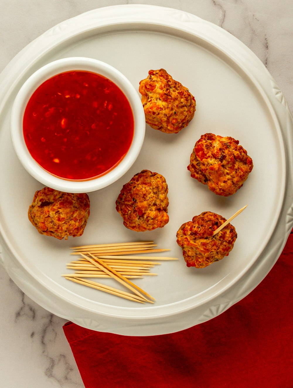 un plato blanco cubierto con albóndigas y ketchup