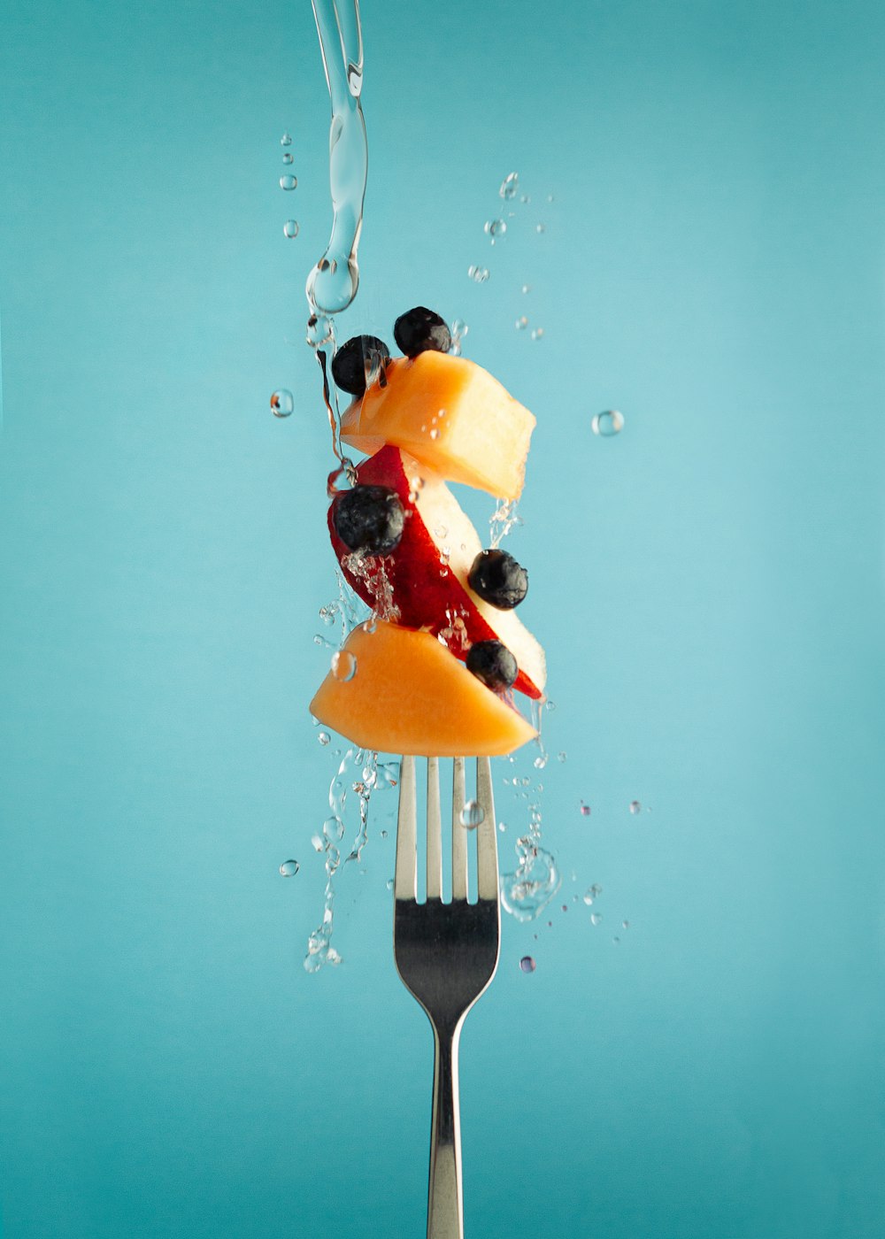 a fork with a piece of fruit on top of it