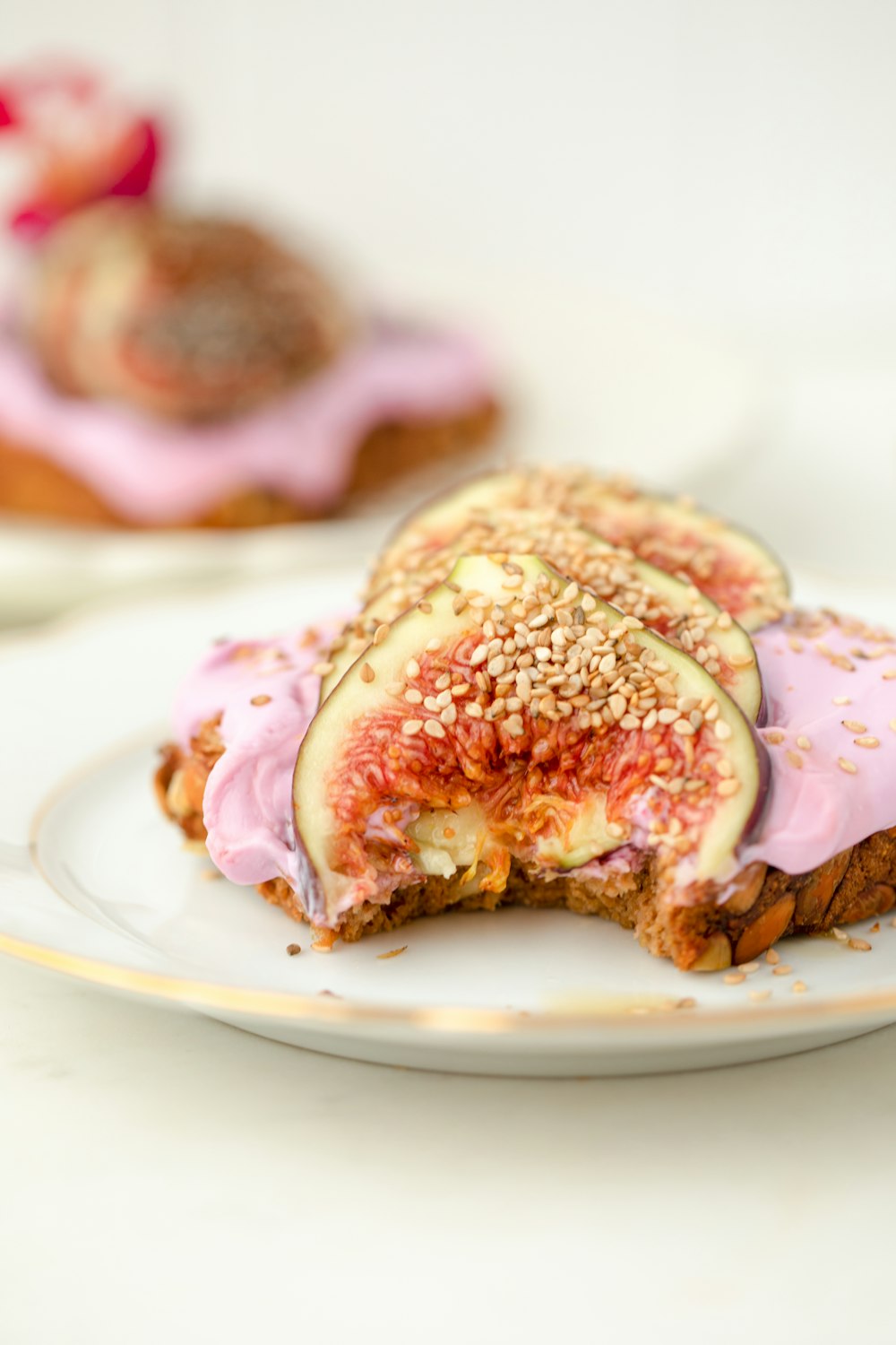 a piece of toast with a pink frosting and sprinkles on it