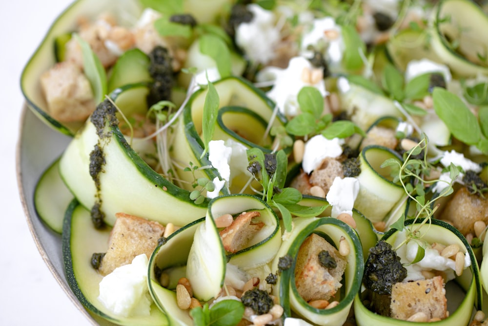 a plate of zucchini, spinach, and goat cheese salad