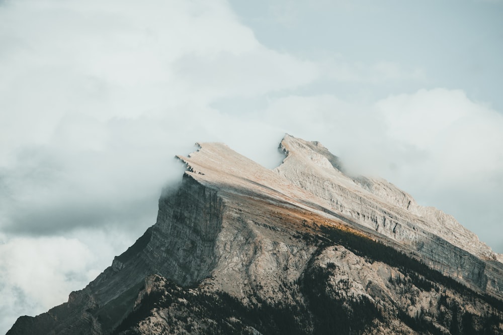 a very tall mountain with some clouds in the sky