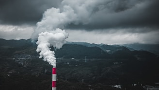 a smokestack emits from a pipe on a cloudy day