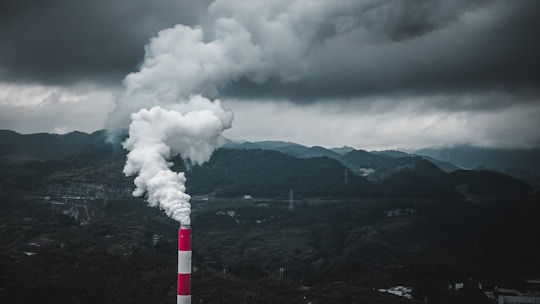 a smokestack emits from a pipe on a cloudy day