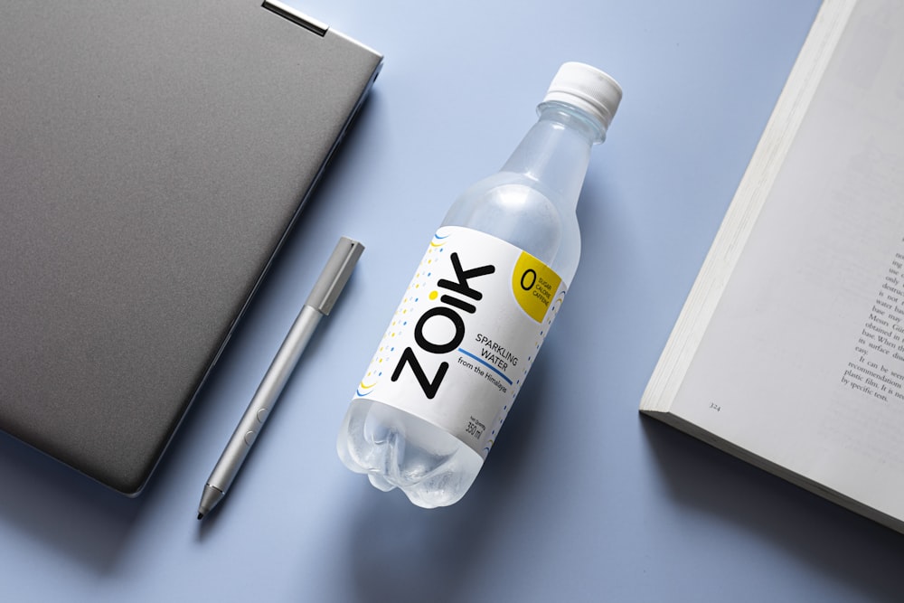 a bottle of water next to a notebook and pen