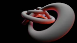 A glowing gold 3D abstract shape with depth shadows on a sleek black background.
