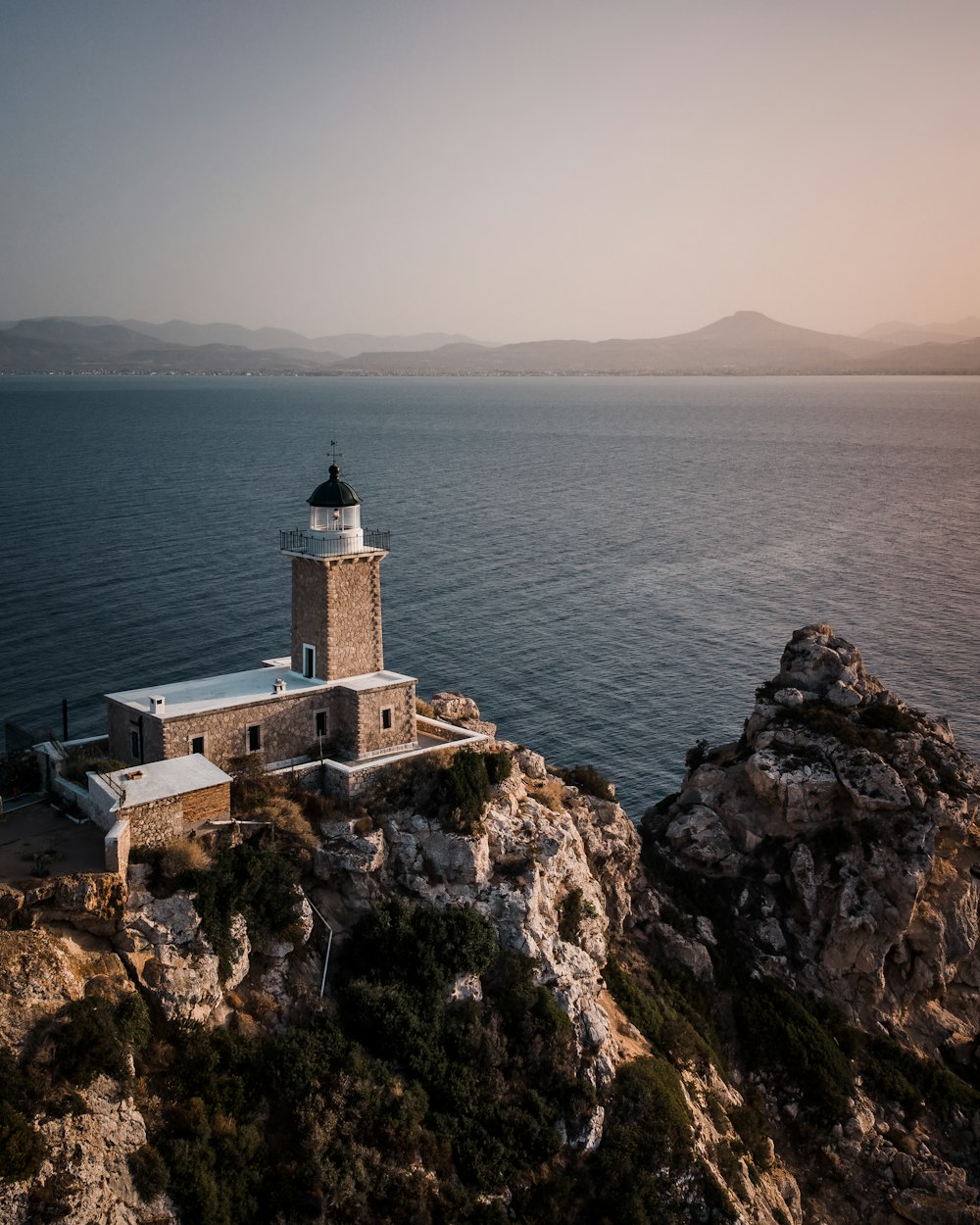 a lighthouse on a rocky cliff overlooking the ocean