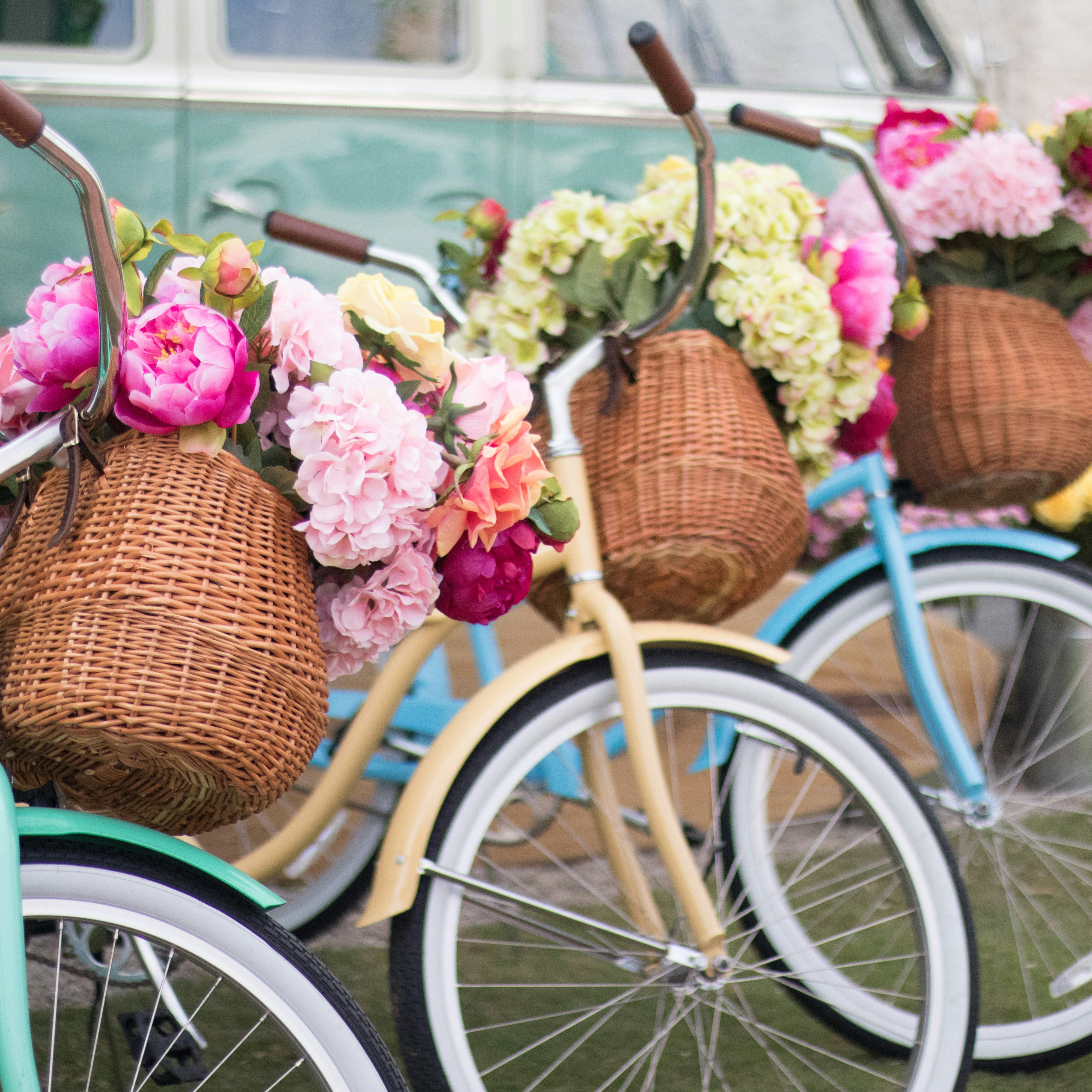 a row of bicycles with baskets full of flowers