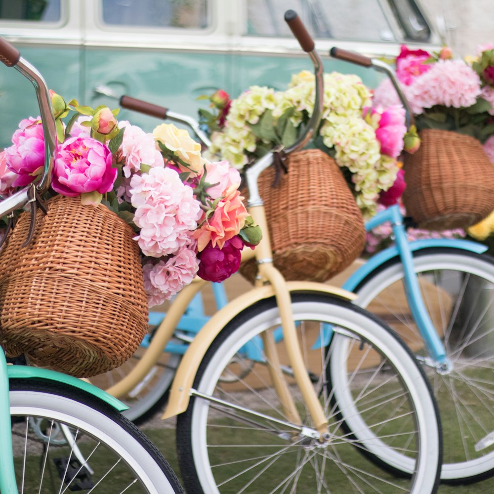 uma fileira de bicicletas com cestos cheios de flores