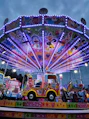 a brightly lit carnival ride with a colorful car