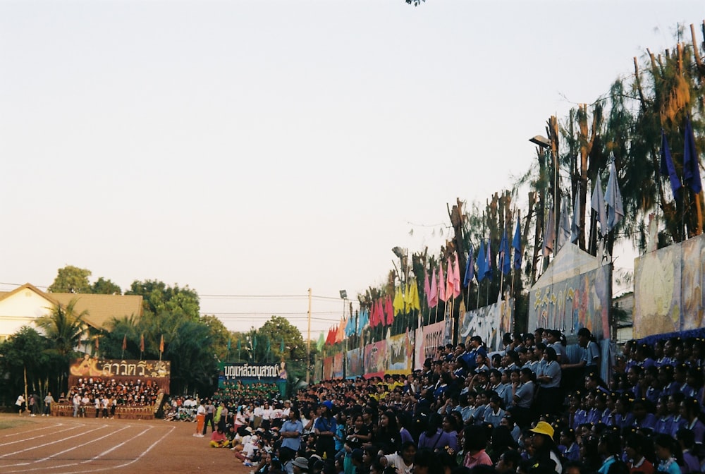 a crowd of people watching a plane fly overhead