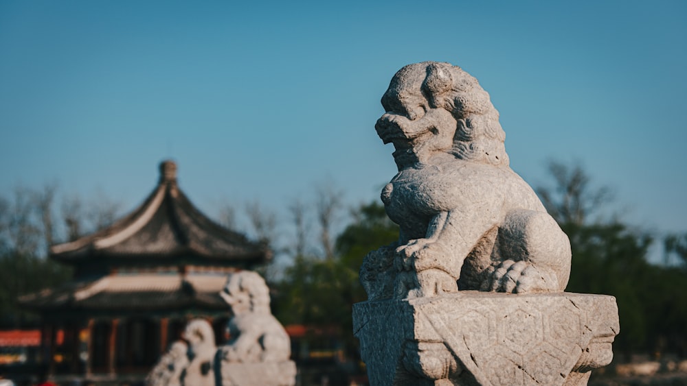 a stone lion statue in front of a pagoda