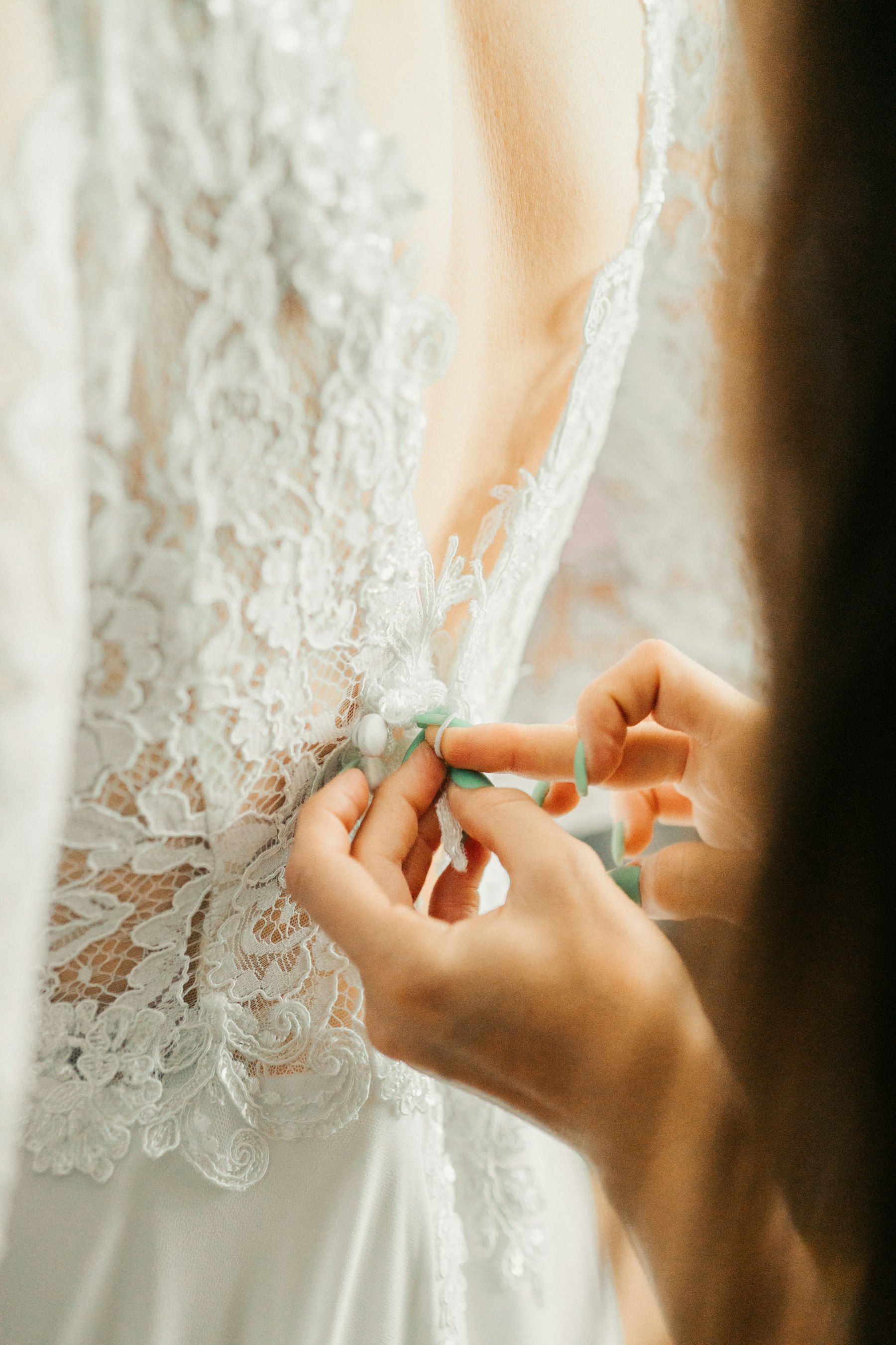 A wedding dress being adjusted during a fitting.
