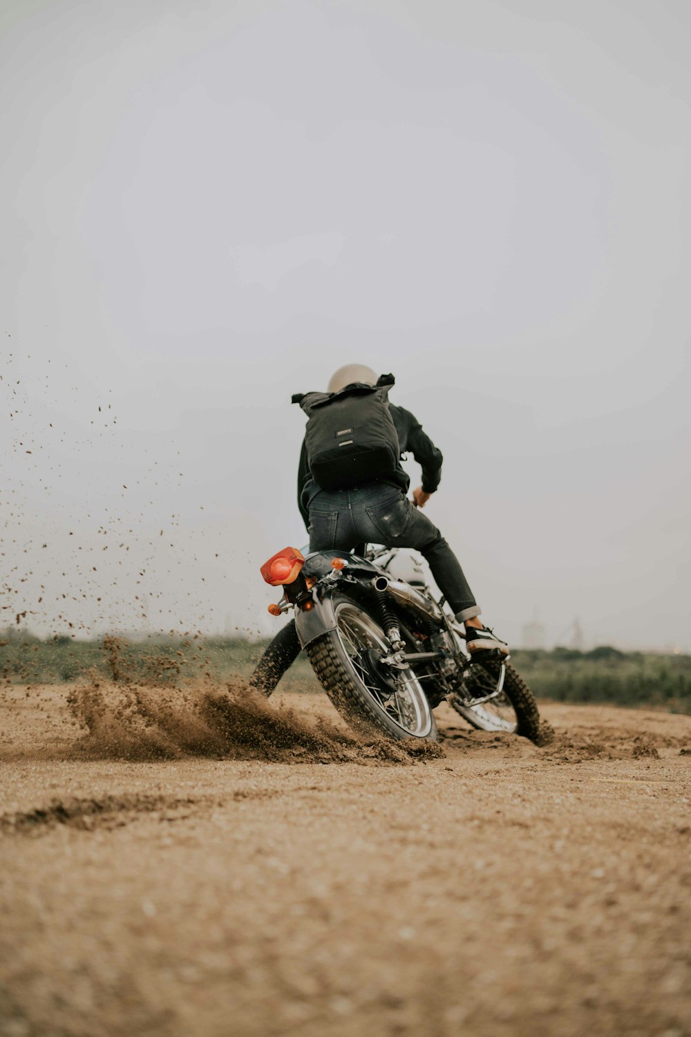 a person riding a motorcycle down a dirt road