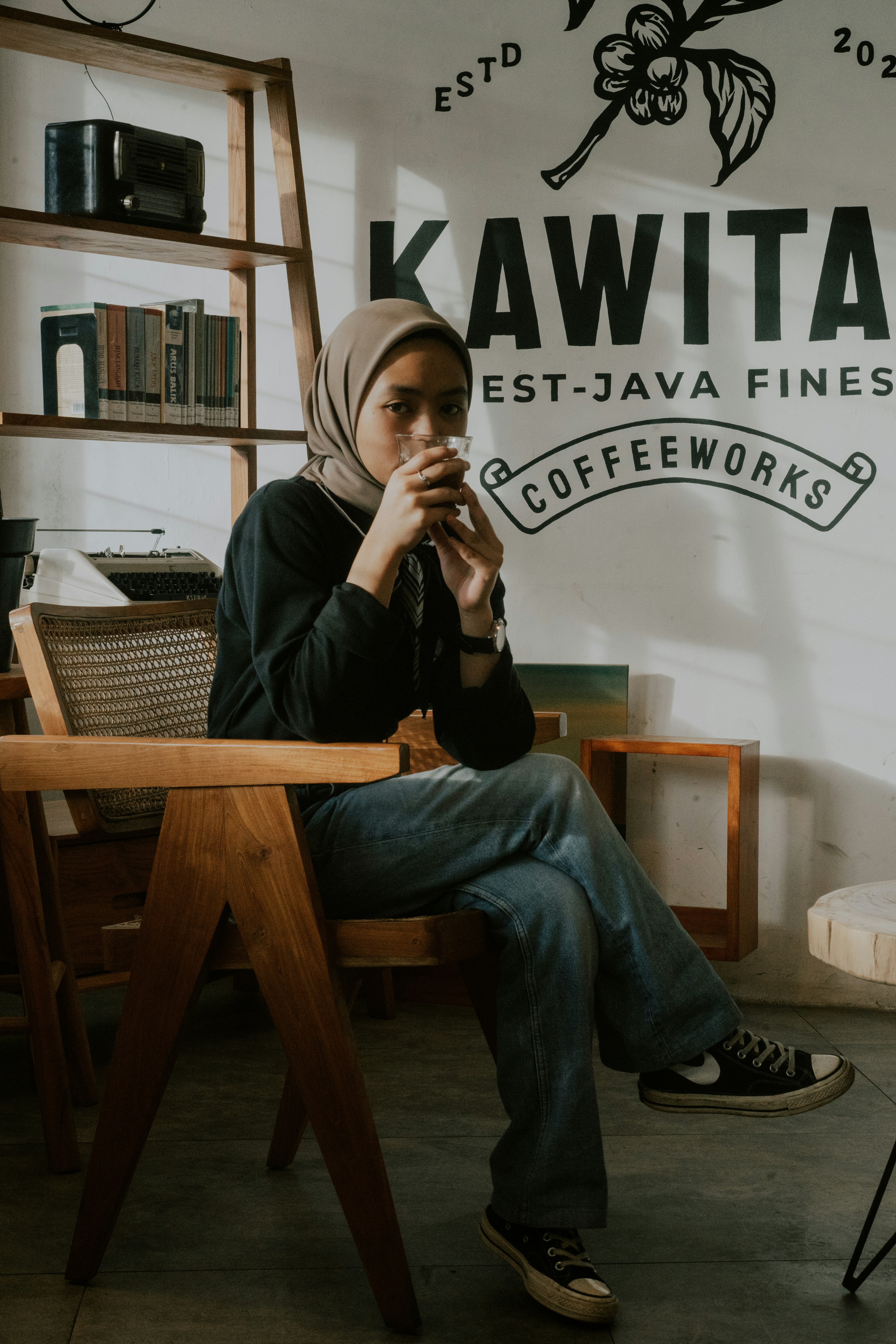 a woman sitting on a chair in front of a sign