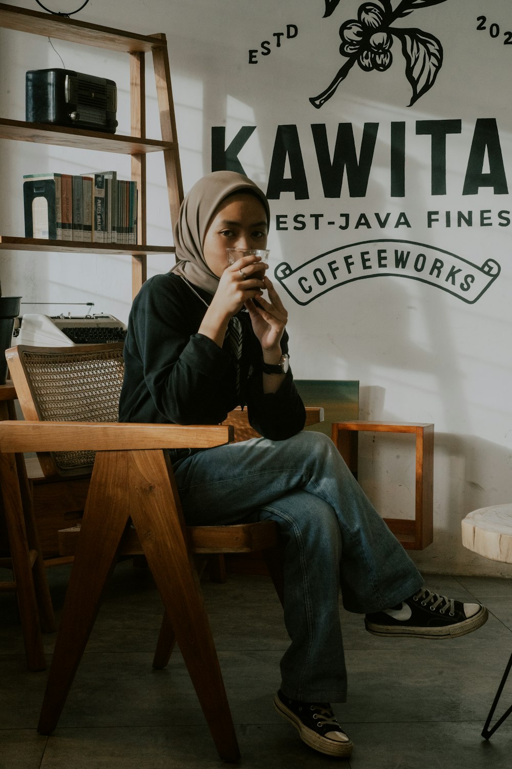 a woman sitting on a chair in front of a sign