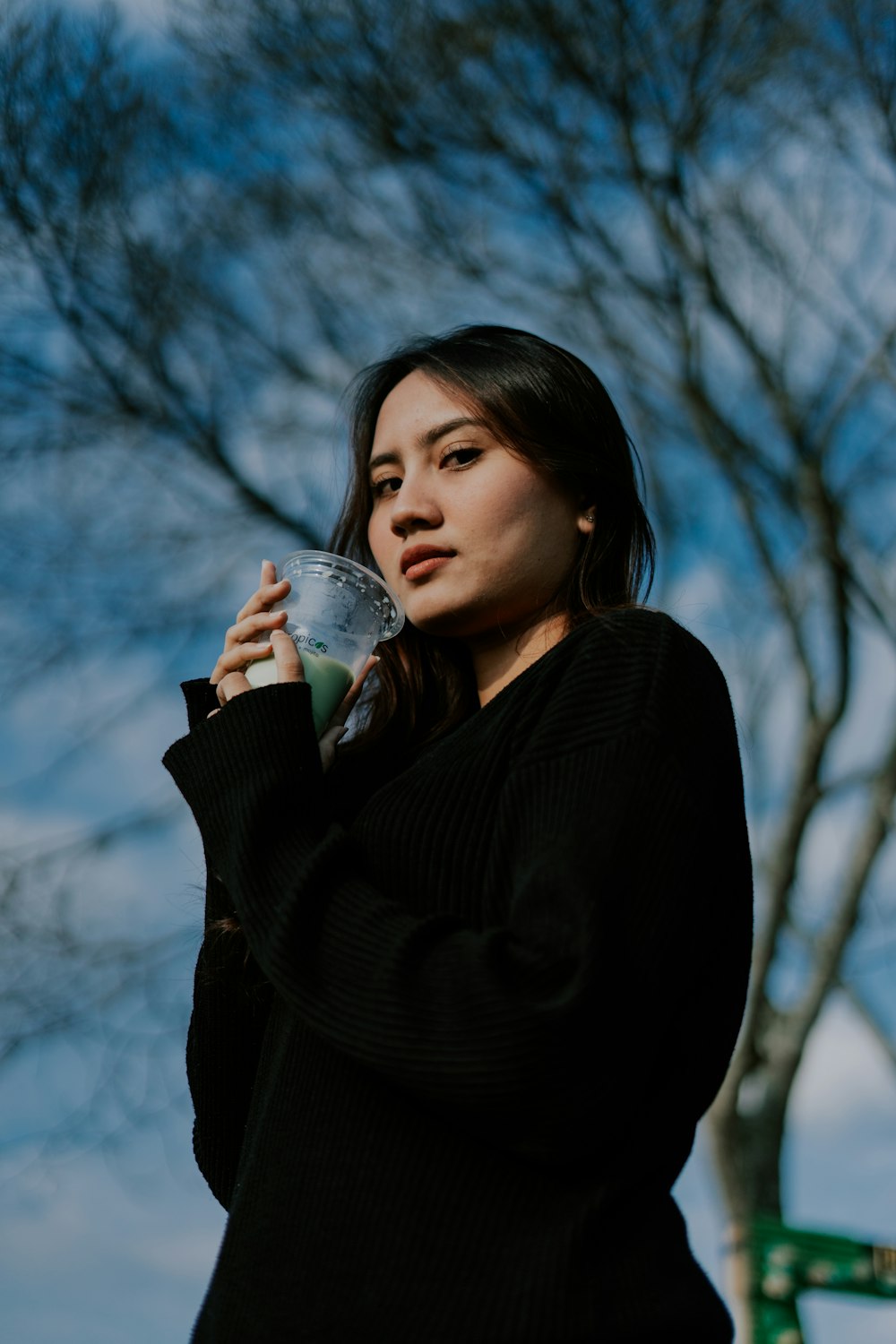 a woman holding a drink in her right hand