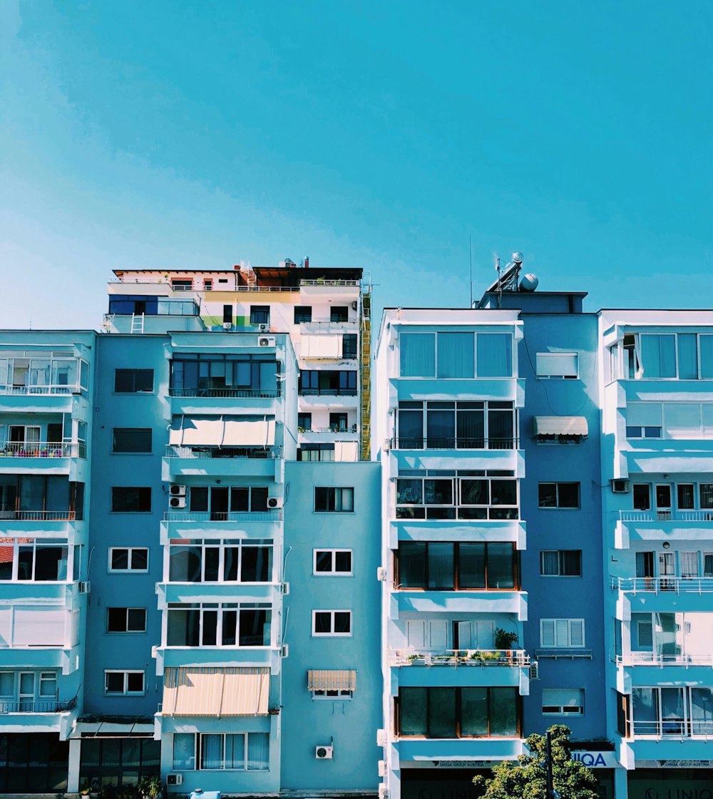 a tall blue building with balconies and balconies on top of it