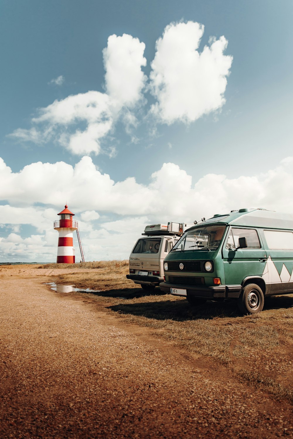 a van parked next to a red and white lighthouse