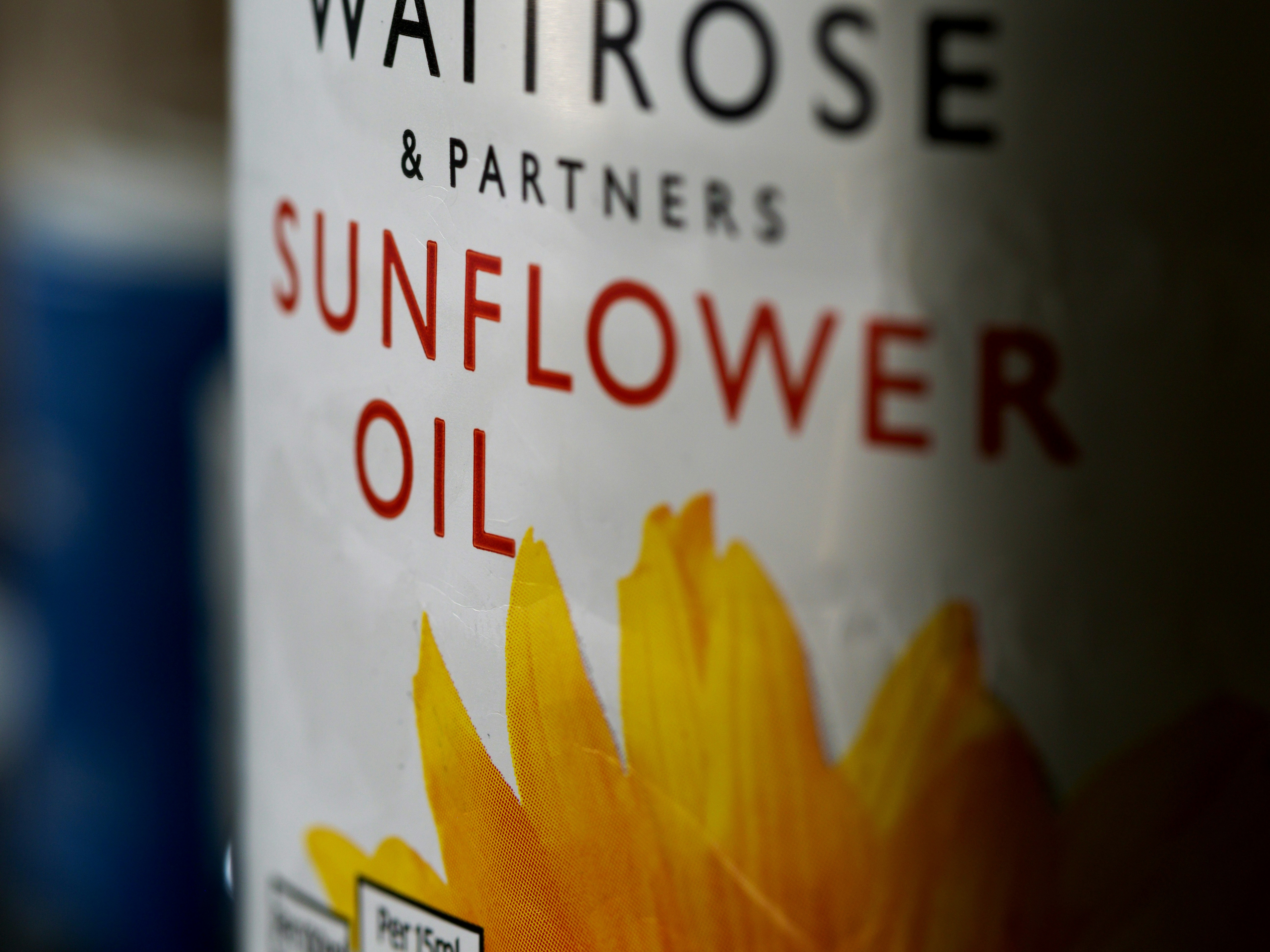 Canola oil bottle with yellow canola flowers in background