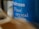 Close-up of a blue container labeled 'Waitrose Fine crystal sea salt,' with slightly blurred elements in the foreground creating a sense of depth.