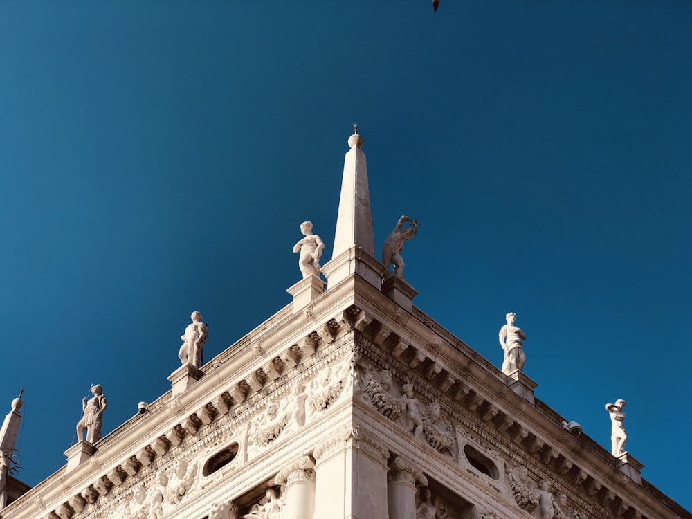 a tall building with statues on top of it