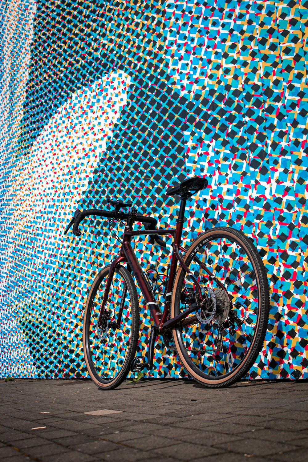 a bicycle parked in front of a colorful wall