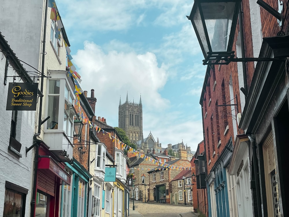 a narrow city street with a church in the background