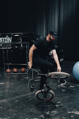 Young BMX coach in action during a training session on a sleek black background.