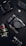 A variety of professional camera equipment includes a Lumix camera with protective casing, a DSLR camera body, and several camera lenses. A padded case with an FX logo is also visible. The equipment is arranged on a dark surface, showcasing the gear's sleek and robust design.