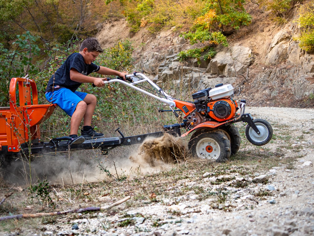 a man riding on the back of an orange tractor