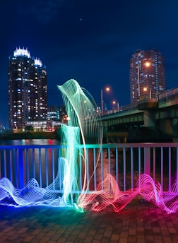 a sculpture of a bird on a city street at night