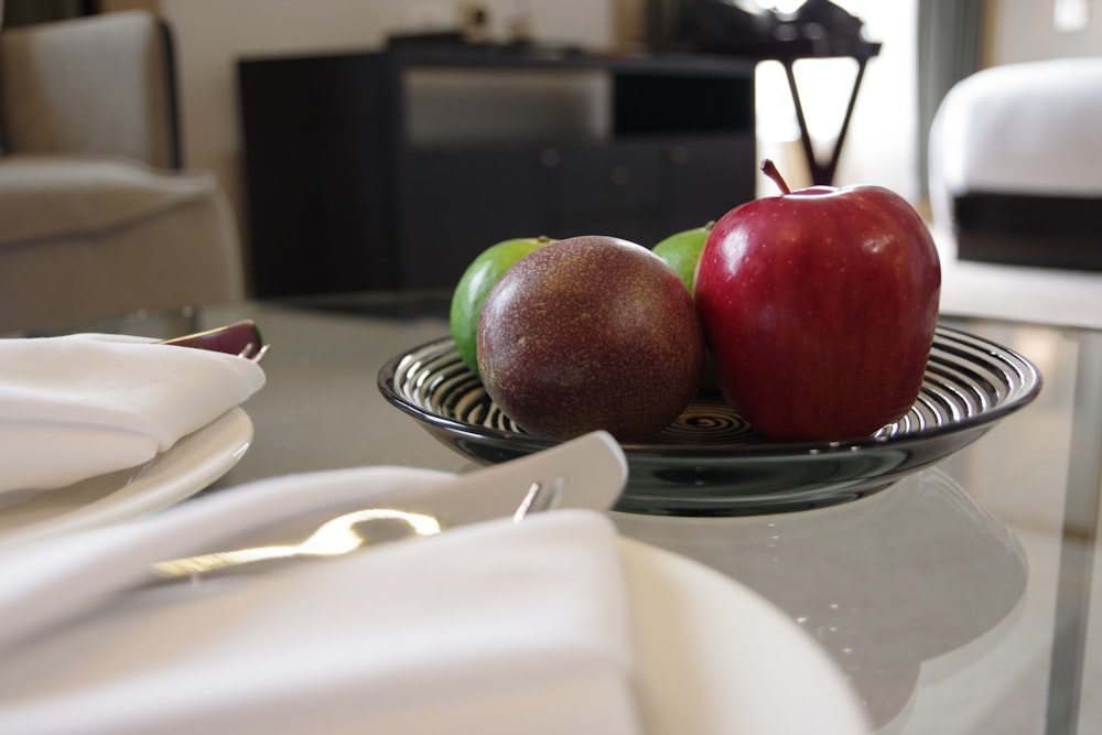 a glass table topped with two apples and a knife