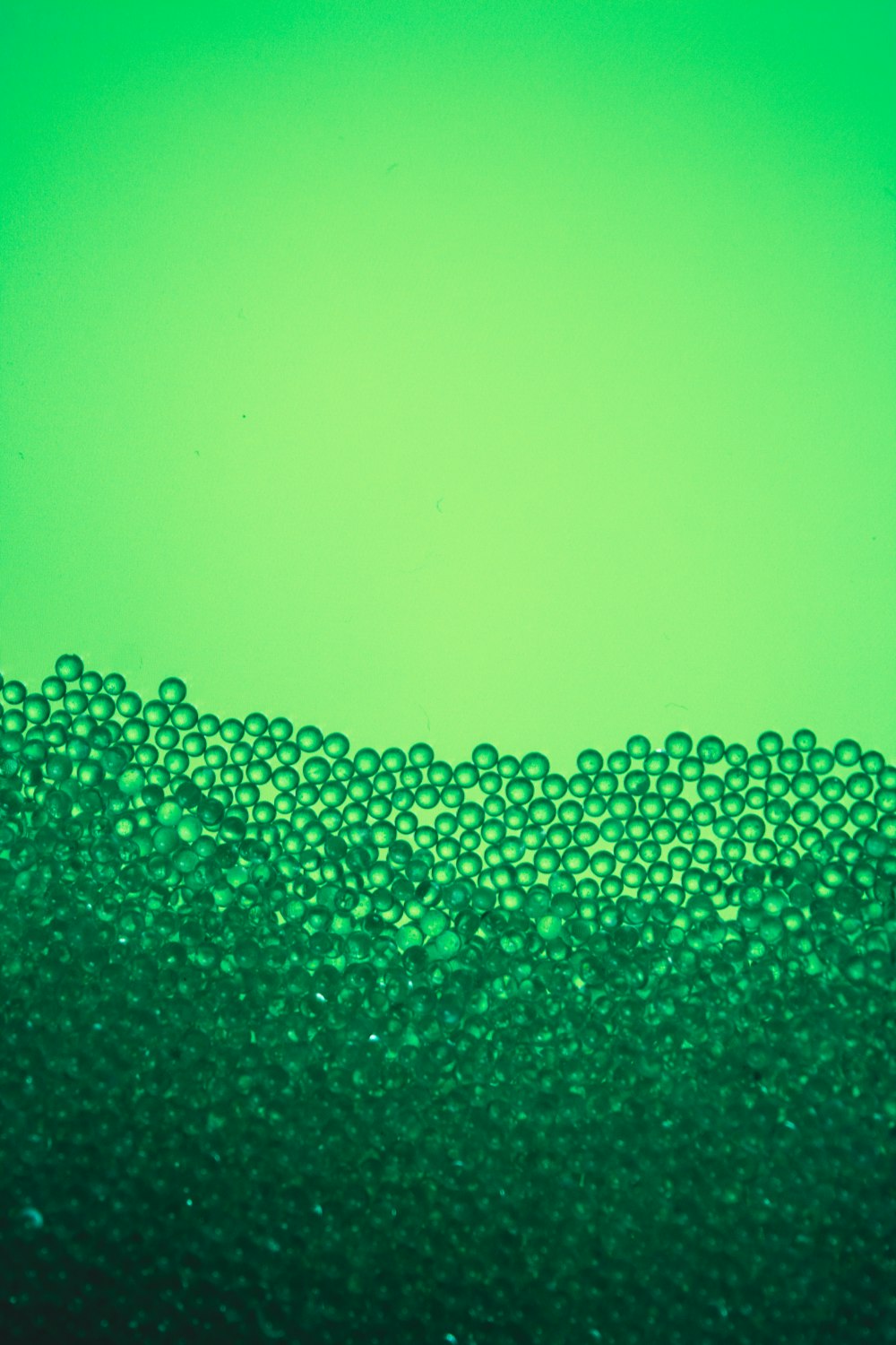 a close up of a green liquid filled with bubbles