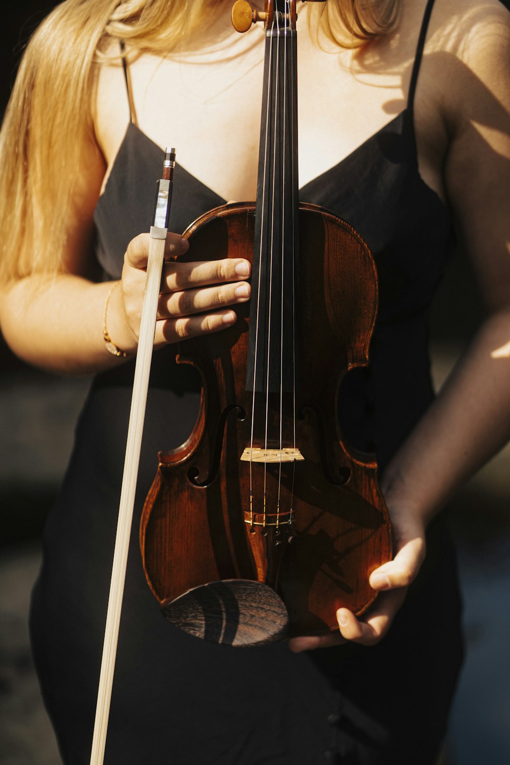 a woman in a black dress holding a violin