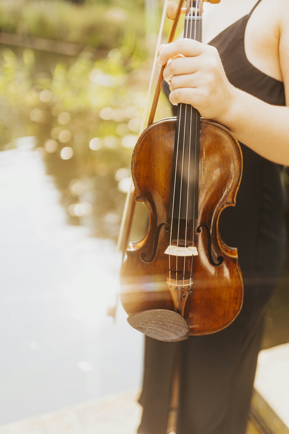 Una mujer sosteniendo un violín en su mano derecha